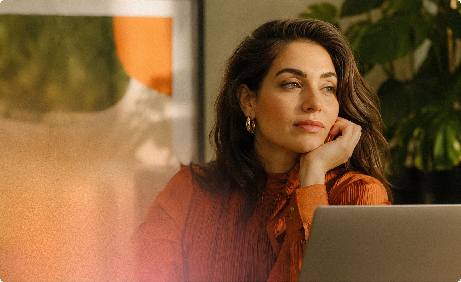 A writer at a laptop in warm natural light, working without a phone or a second screen in reach.